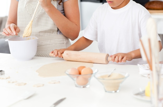 Gros plan de la mère et le fils qui préparent une pâte ensemble