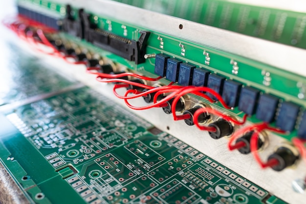 Gros plan sur des microcircuits complexes et des cartes vertes sur panneau connectés les uns aux autres à l'aide de fils