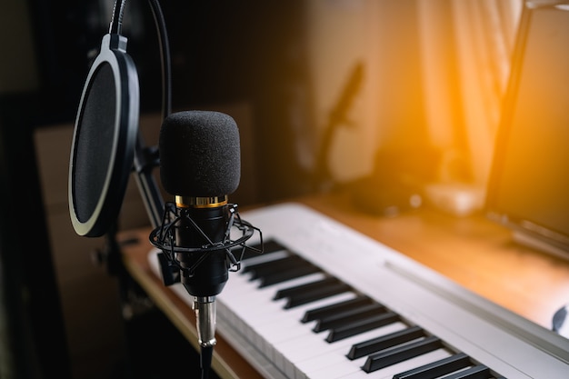 Gros plan sur un microphone et un piano dans la salle d'enregistrement sonore