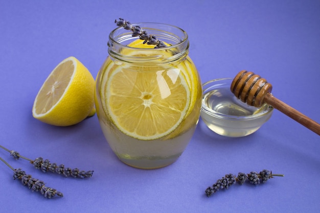 Gros plan sur le miel avec du citron dans le bocal en verre