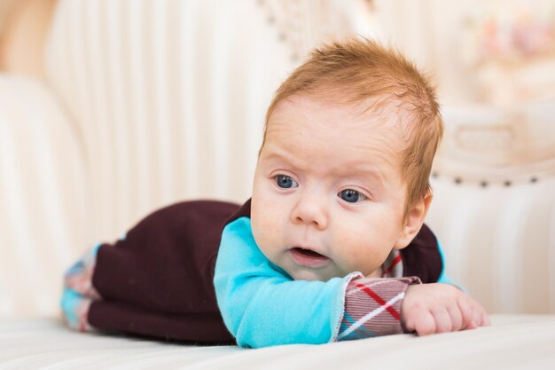 Photo un gros plan d'une mignonne petite fille allongée sur le lit à la maison.