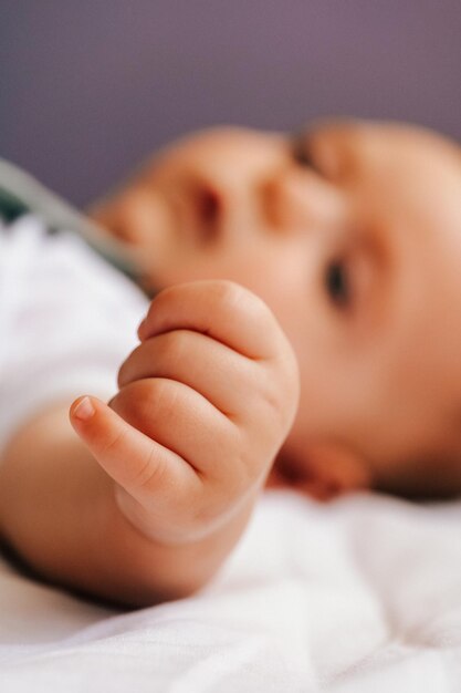 Un gros plan d'une mignonne petite fille allongée sur le lit à la maison.