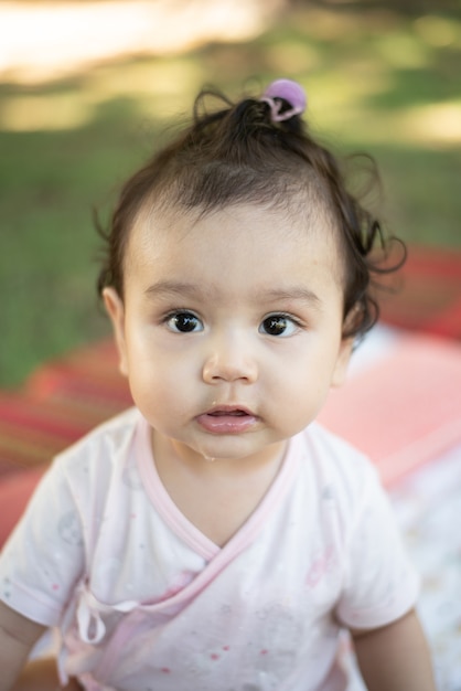 Photo gros plan d'une mignonne petite fille asiatique regardant la caméra sur fond flou, regardant la caméra