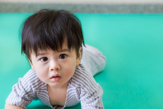 Gros plan de mignons petits vêtements de bébé aiment jouer sur le sol dans la maison.