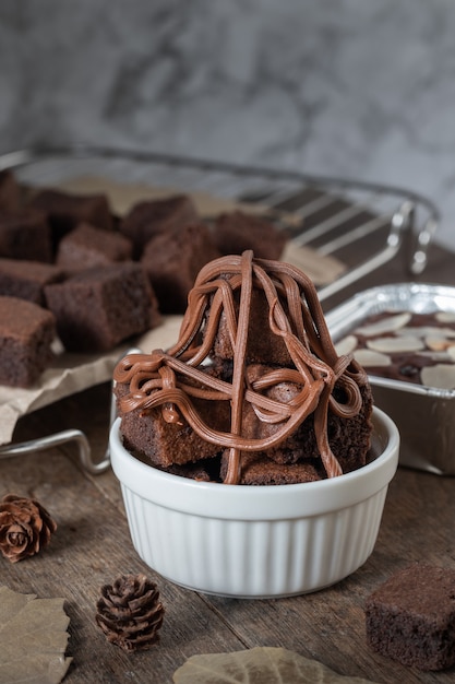Gros plan sur un mini brownie au chocolat, un dessert au lait sur fond sombre sur une table en bois.