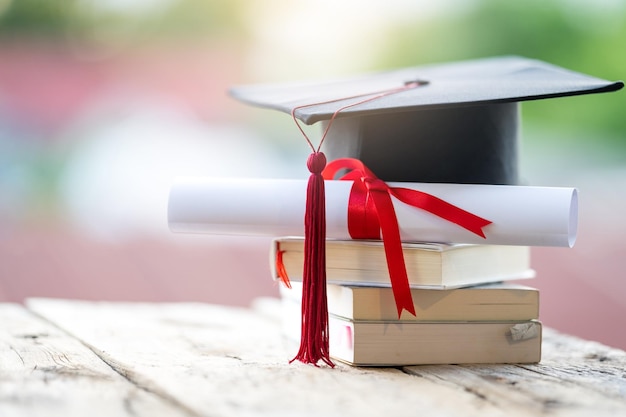 Gros plan sur une mise au point sélective d'un chapeau de graduation ou d'un mortier et d'un certificat de diplôme mis sur la table