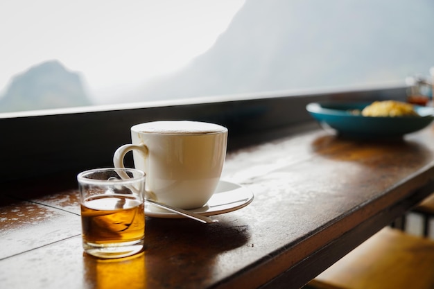 Gros plan et mise au point sélective tasse blanche de café chaud sur la table en bois au restaurant ou au café.