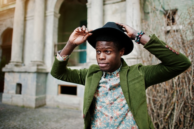 Gros plan mode portrait d'homme afro-américain noir sur une veste en velours vert et un chapeau noir