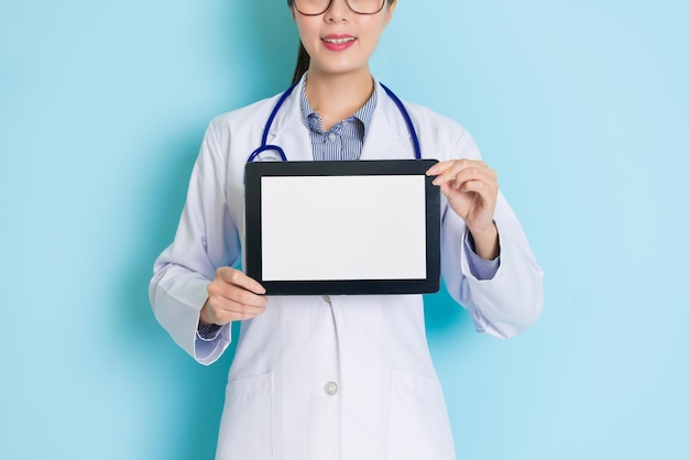 gros plan montrant une tablette tenant dans les mains d'une femme médecin qui a un joli smiley.