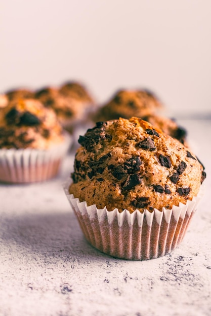 Gros plan de muffins aux pépites de chocolat sur fond blanc.