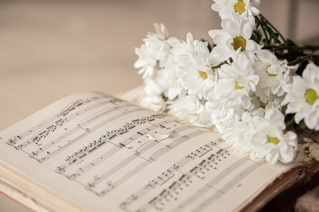 Gros plan sur des notes de musique et un bouquet de fleurs.