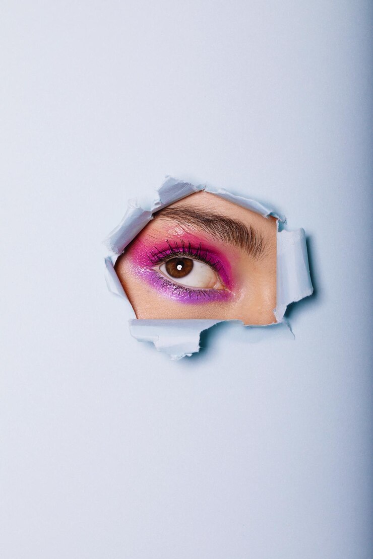 Photo un gros plan de l'œil d'une femme regardant à travers un papier déchiré