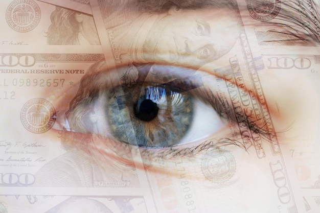 Photo gros plan sur l'œil humain avec des dollars dans la pupille. concept - argent dans les yeux.