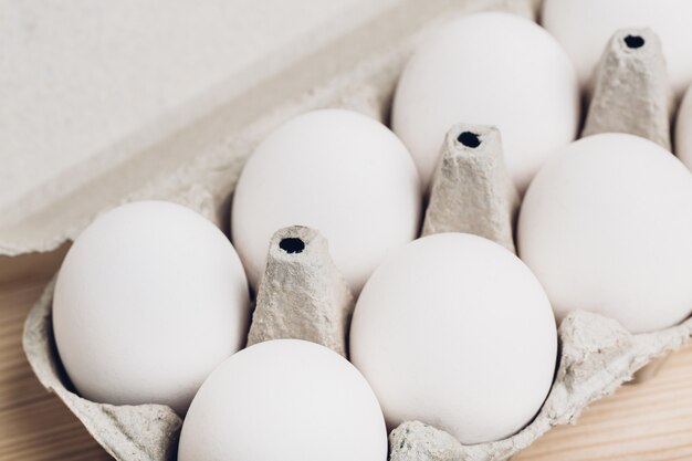 Photo gros plan d'œufs de poule dans une boîte. lumière douce