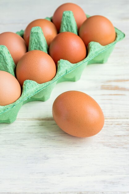 Photo gros plan d'oeufs de poulet brun cru dans une boîte en carton d'oeufs