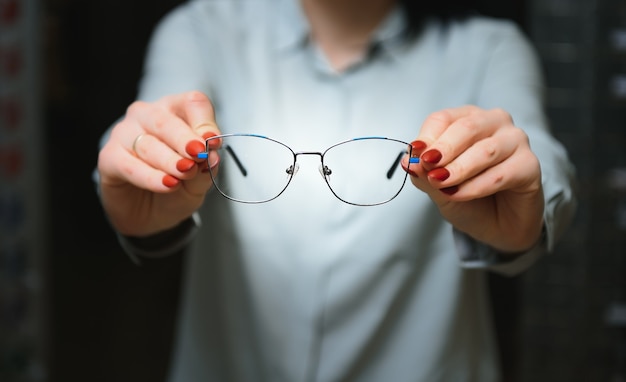 Gros plan de l'optométriste, opticien donnant des lunettes à essayer