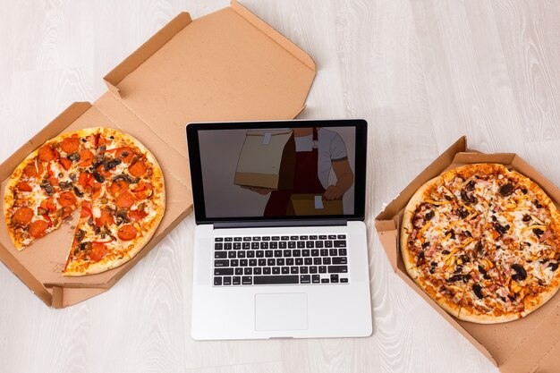 Gros plan sur un ordinateur portable avec une pizza appétissante sur fond blanc