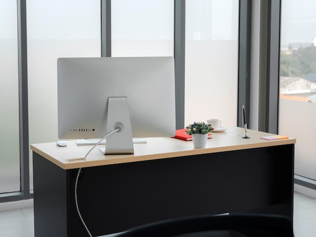 Gros plan sur un ordinateur sur une table en bois dans un bureau de travail moderne