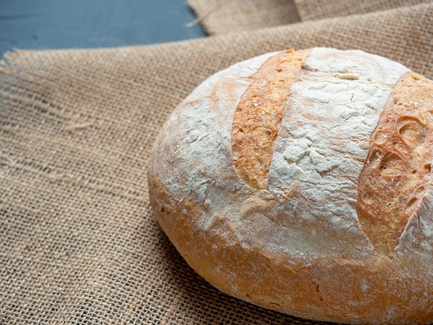 Gros plan de pain de blé rond croustillant frais sur fond sombre Vue latérale Le concept de boulangeries