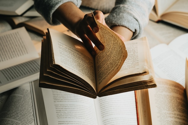 Gros plan d'une paire de mains noires lisant un vieux livre