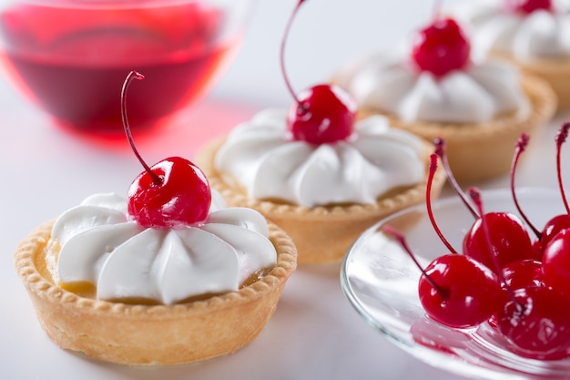 Photo gros plan d'un panier de sablés à la crème et aux cerises. fabrication de pâtisseries et gâteaux.