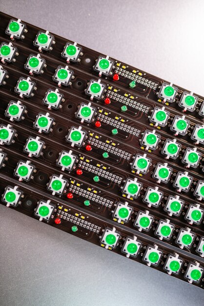 Le gros plan d'un panneau LED d'indicateurs de lumière verte est en cours de production. Le concept de production industrielle d'équipements à des fins militaires et stratégiques