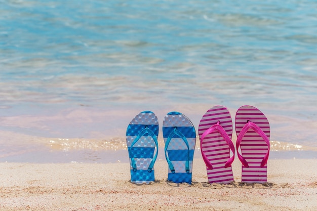 Gros plan sur des pantoufles sur une plage tropicale