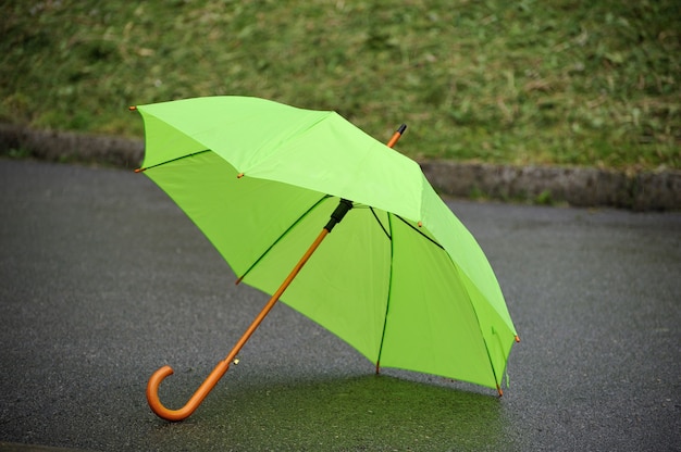 Gros plan parapluie vert sur fond d'herbe