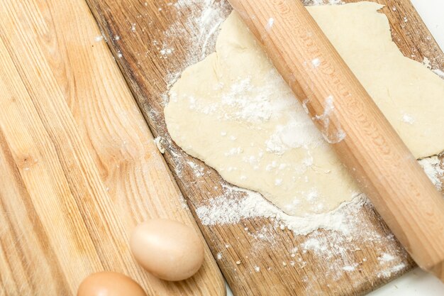 Gros plan de la pâte allongée sur une planche de cuisson en bois