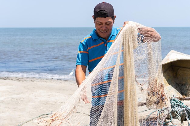 Gros plan d'un pêcheur fixant son filet de pêche avec une corde