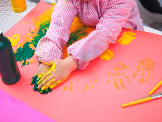 Gros plan sur une peinture à la main d'enfants avec des aquarelles colorées