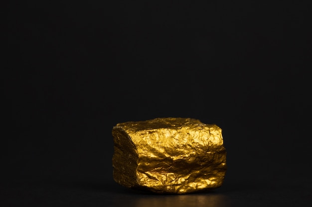 Gros plan de pépite d&#39;or ou de minerai d&#39;or sur fond noir