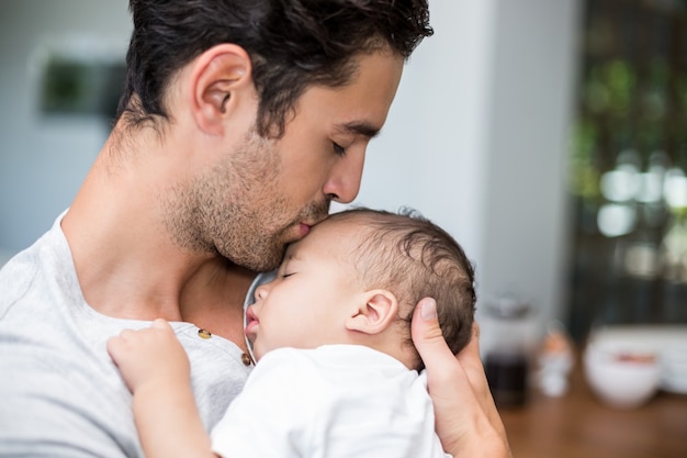 Gros plan, père, embrasser, bébé, debout