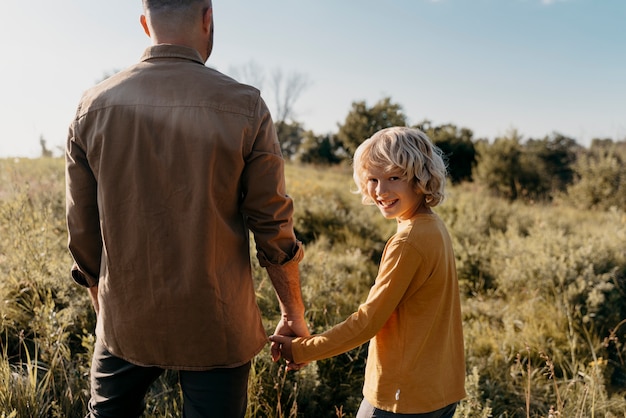 Gros plan père et enfant main dans la main