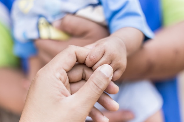 Gros plan d&#39;un père de main dans la main de bébé