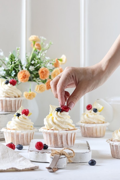 Gros plan d'une personne tenant un cupcake au citron