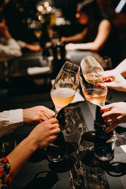 Gros plan de personnes avec des verres de champagne dans un restaurant.