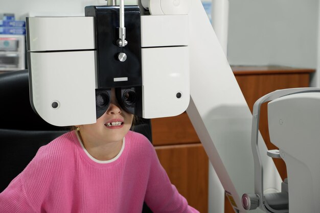 Gros plan d'une petite fille un examen des yeux à la clinique.