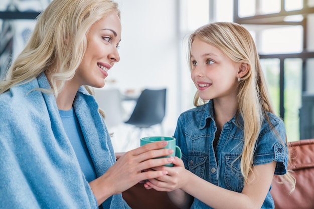 Gros plan d'une petite fille mignonne aidant sa mère à se remettre d'une maladie à la maison