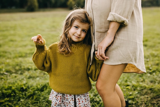 Un gros plan d'une petite fille avec sa mère enceinte écoutant ce qui se passe à l'intérieur du ventre