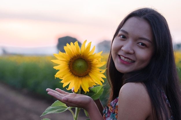 Gros plan photo belle jeune fille avec tournesol à fleur déposée le matin