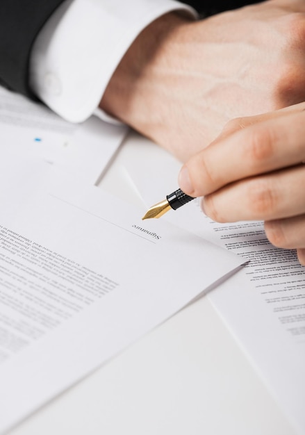 gros plan photo d'un homme signant un contrat à la main