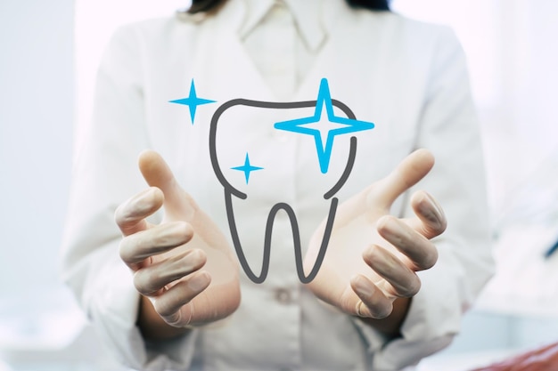 Gros plan sur la photo des mains du dentiste sur l'arrière-plan du lieu de travail, un professionnel de la santé remis tenant un objet dentaire virtuel ou un produit d'article. Concept de santé et de publicité, espace de copie