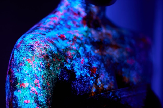 Gros plan photo de peau de femme noire avec des peintures fluorescentes art corporel