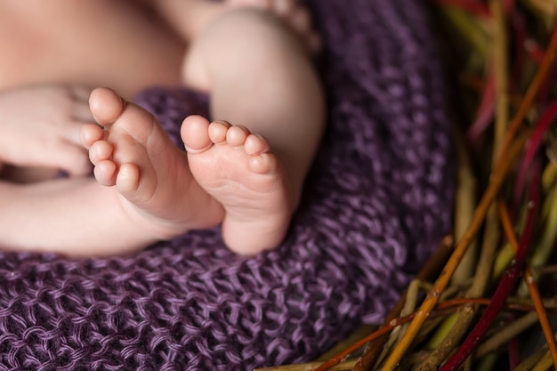 Gros plan photo de pieds de bébé nouveau-né en plaid tricoté