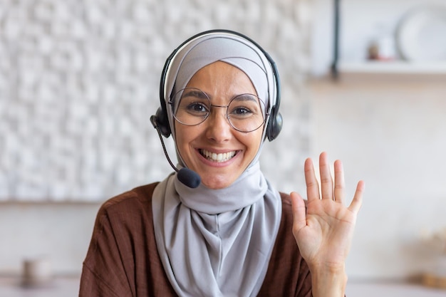 Gros plan photo portrait d'une jeune étudiante musulmane dans un hijab lunettes et un casque il est assis et