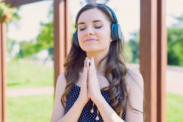 Gros plan photo portrait de satisfaits satisfaits délicats gentils joyeux positifs optimistes appréciant le bon son du nouveau casque gris dame se reposant se détendre méditation