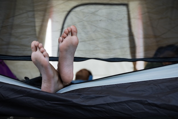 Gros plan sur les pieds de l'enfant en position couchée dans la tente sur le camping