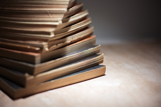 Gros plan d'une pile de livres sur une table en bois.