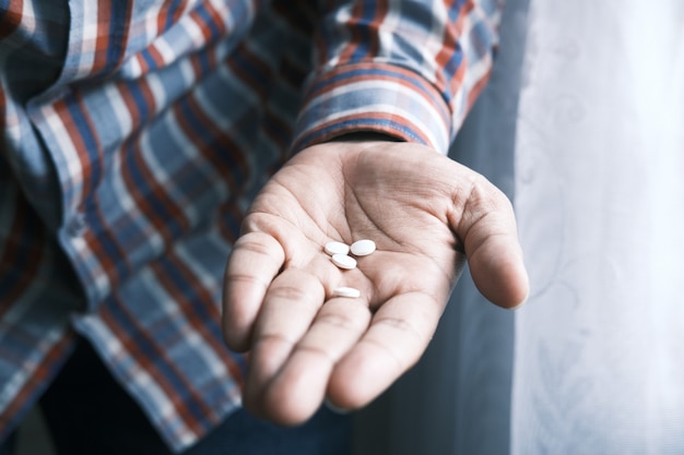 Gros plan d'une pilule médicale de couleur blanche sur la paume de la main